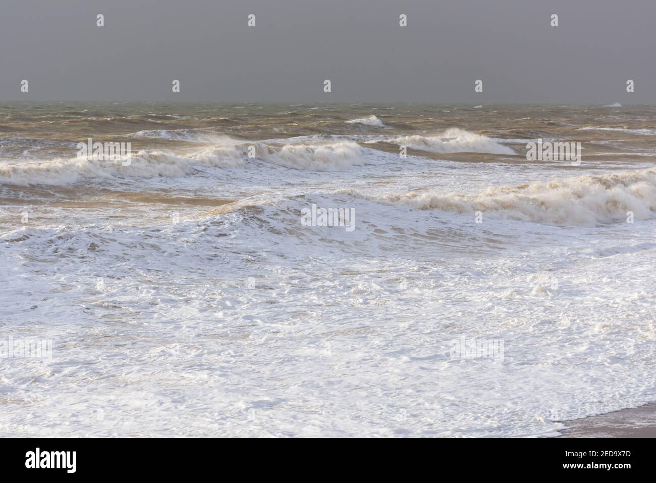 Storm sea sand beach is a neutral color. Natural background in beige shades. The raging elements, the majestic view of the sea surf. Foaming waves rol Stock Photo