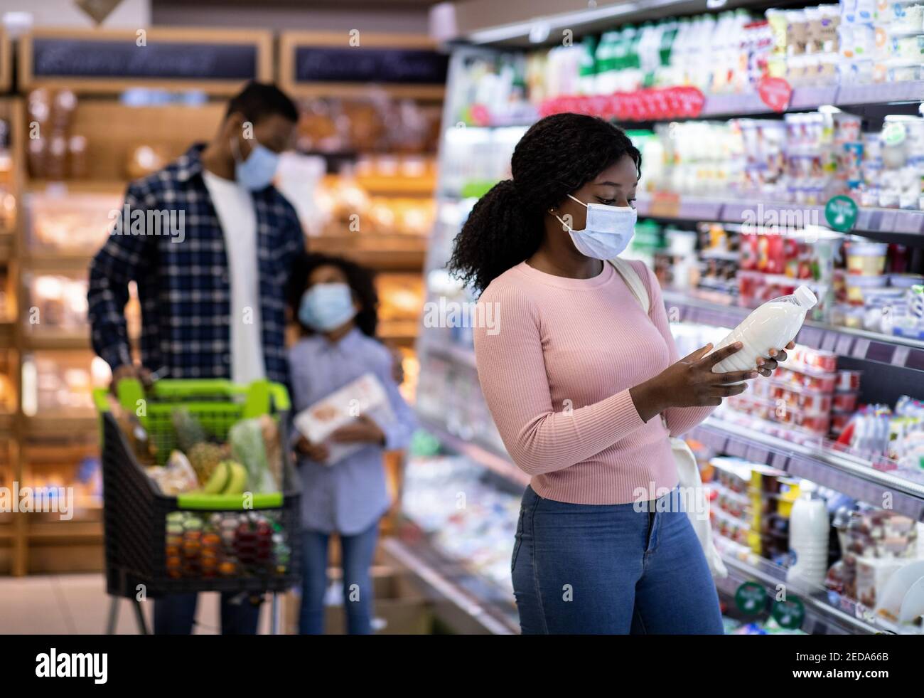 Young Black Woman With Her Family Purchasing Dairy Products At Modern 