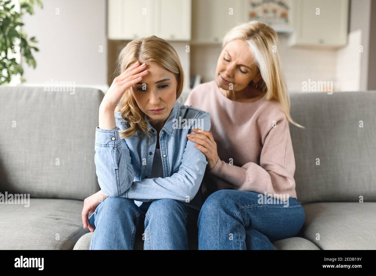 Worried mature mother consoles her adult daughter, helping with problem and depression, caring she, empathy, expressed maternal support. Support of a loved one Stock Photo