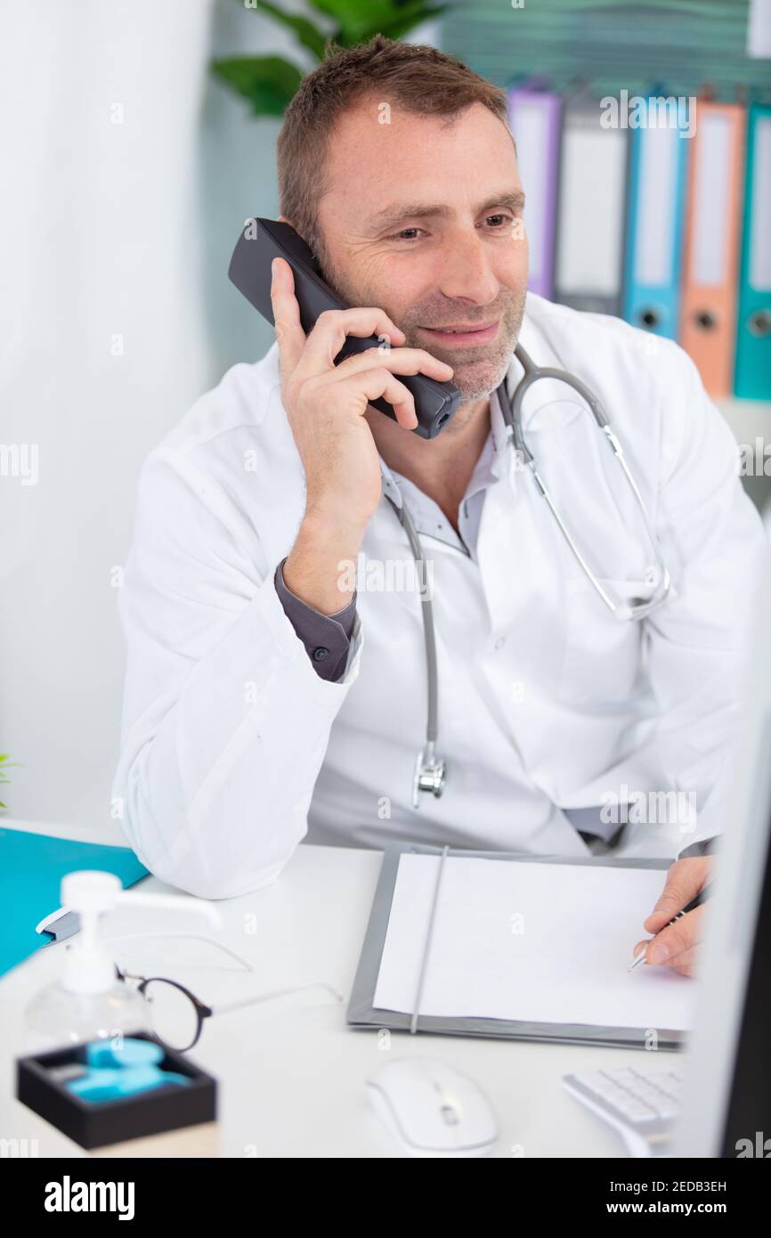 male doctor using computer and telephone at the medical office Stock ...
