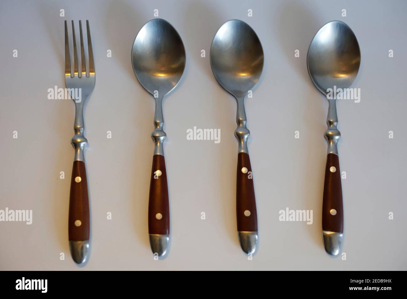 Three spoons and a fork odd-one-out Stock Photo