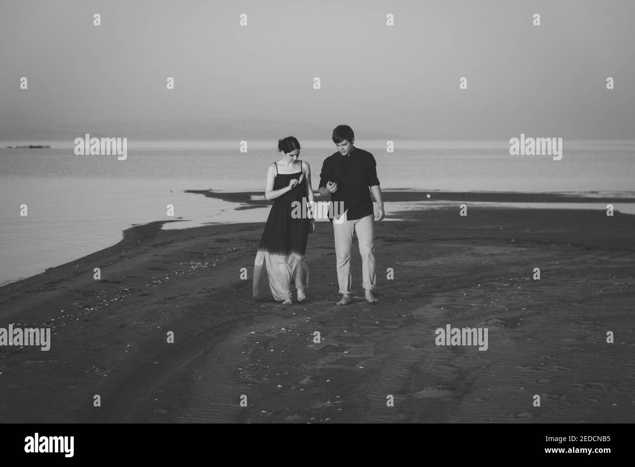 Young man walking along the beach Black and White Stock Photos & Images ...