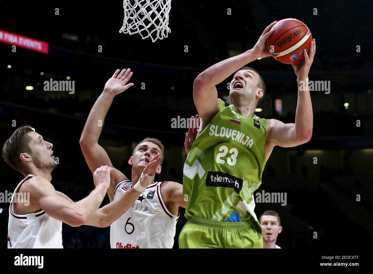 Slovenia's Alen Omic (23) goes for the basket against Latvia's Kaspars  Berzins (L) and Rolands Freimanis (6) during their 2015 EuroBasket 2015  round of 16 match at the Pierre Mauroy stadium in