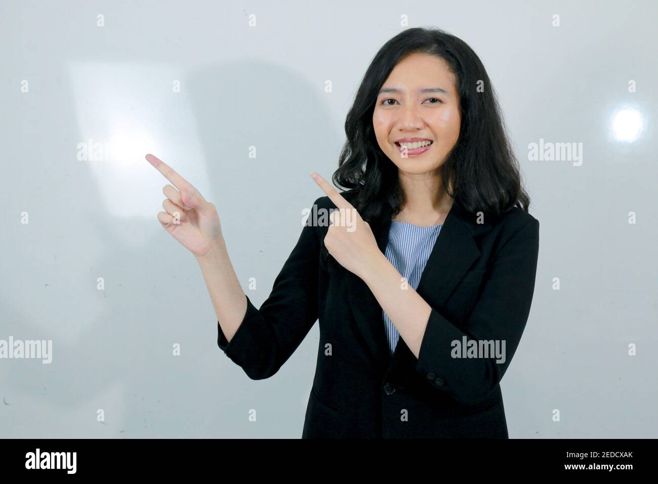Business young asian girl is Happy and smile face with hand point on empty space. Stock Photo