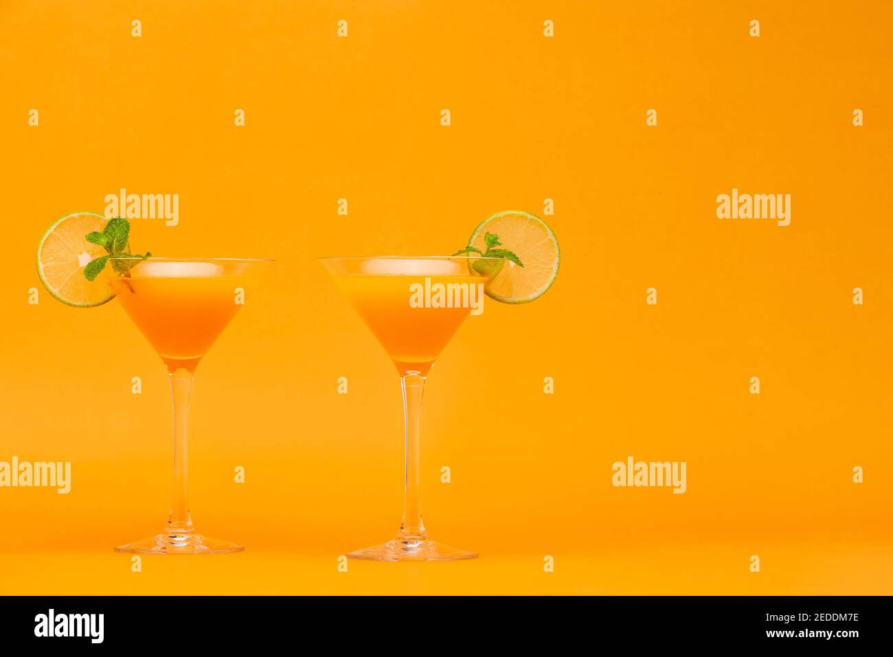 Refreshing orange juice cocktail drinks in the glasses on colorful background Stock Photo