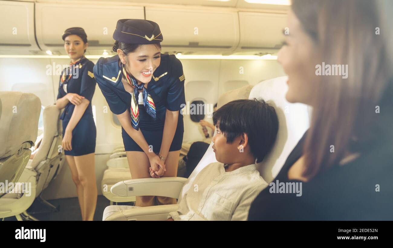 Cabin crew provide service to family in airplane . Airline