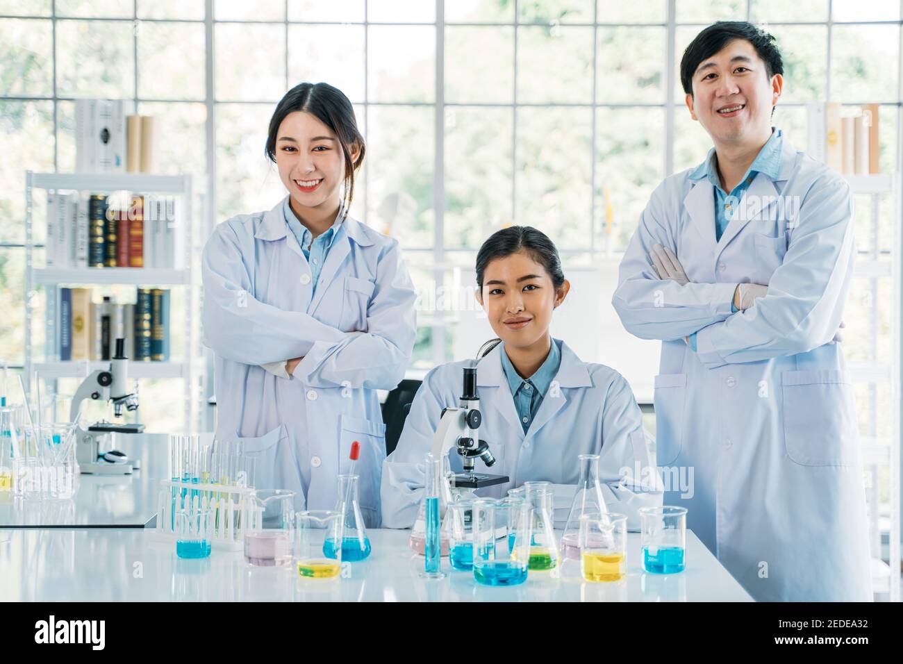 Portrait of successful team of male and female Asian medical researcher and scientist working in medical lab wearing labcoat looking at camera with crossed arms Stock Photo