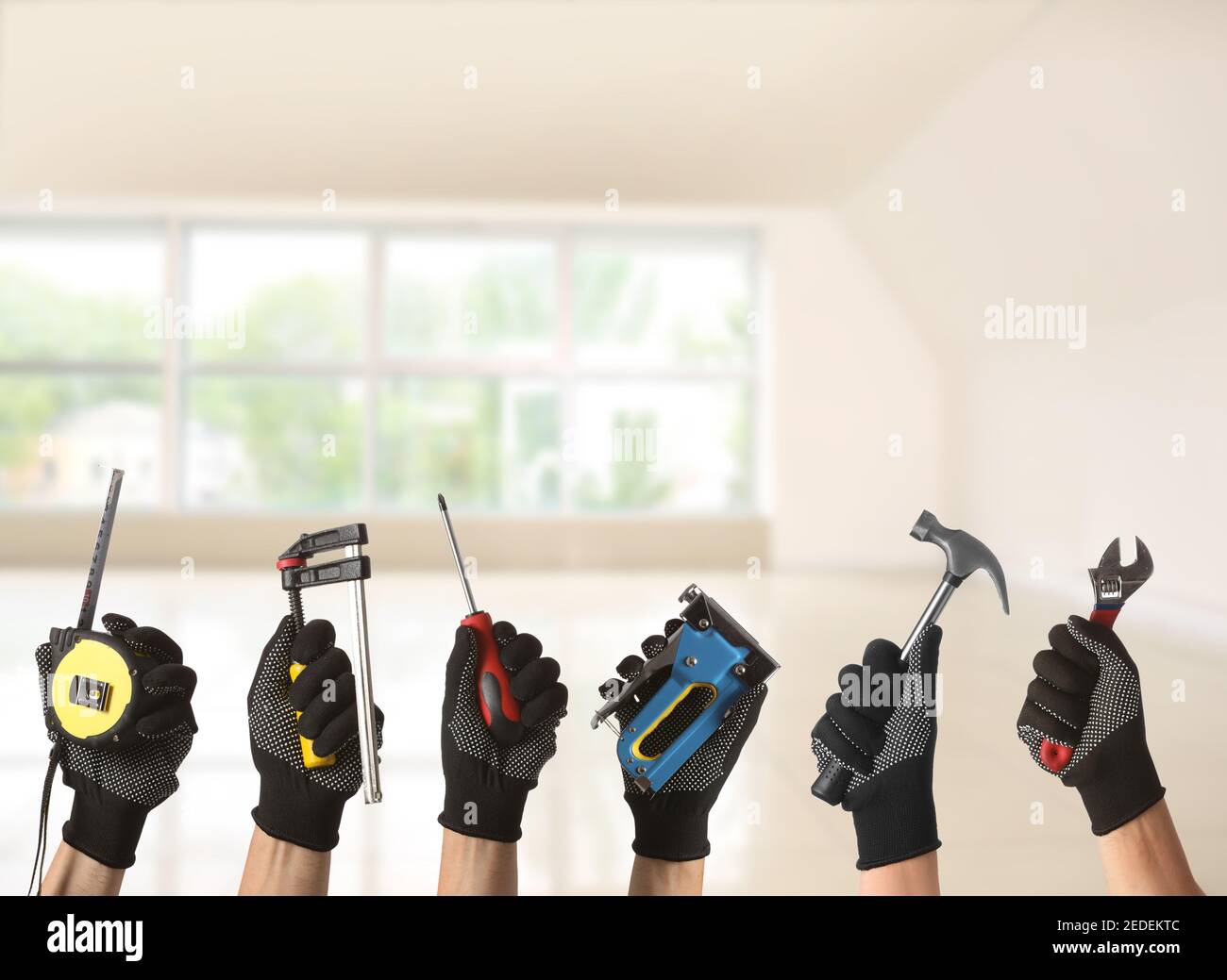 Many hands with different construction tools indoors Stock Photo