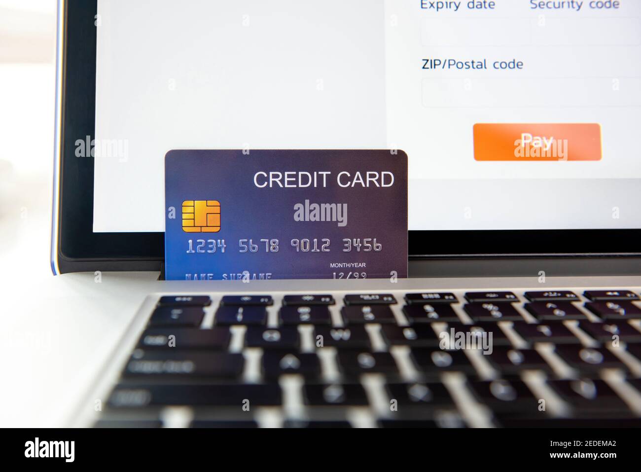 Credit card on laptop computer representing online shopping payment or electronic transactions Stock Photo