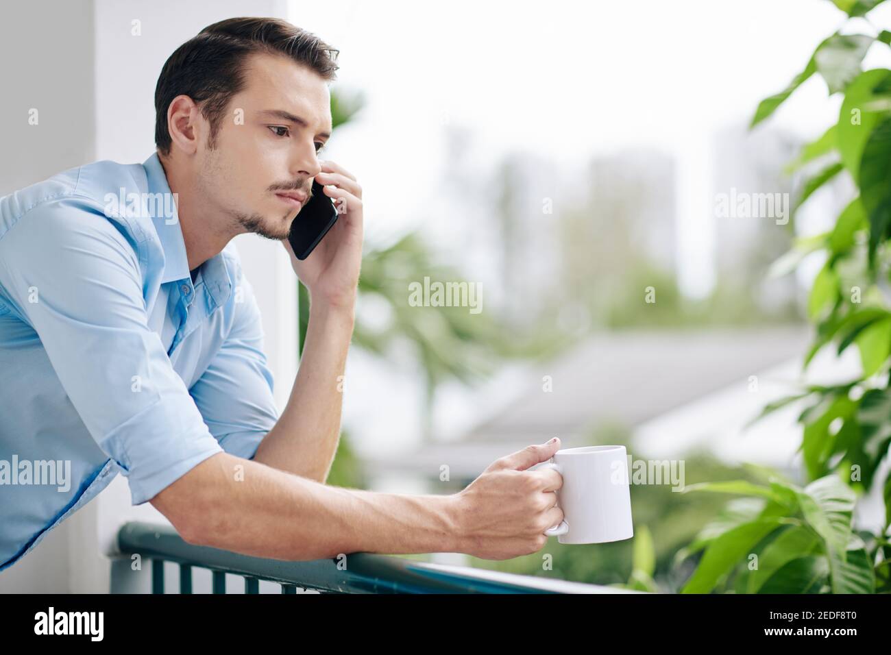Frowning man talking on phone Stock Photo