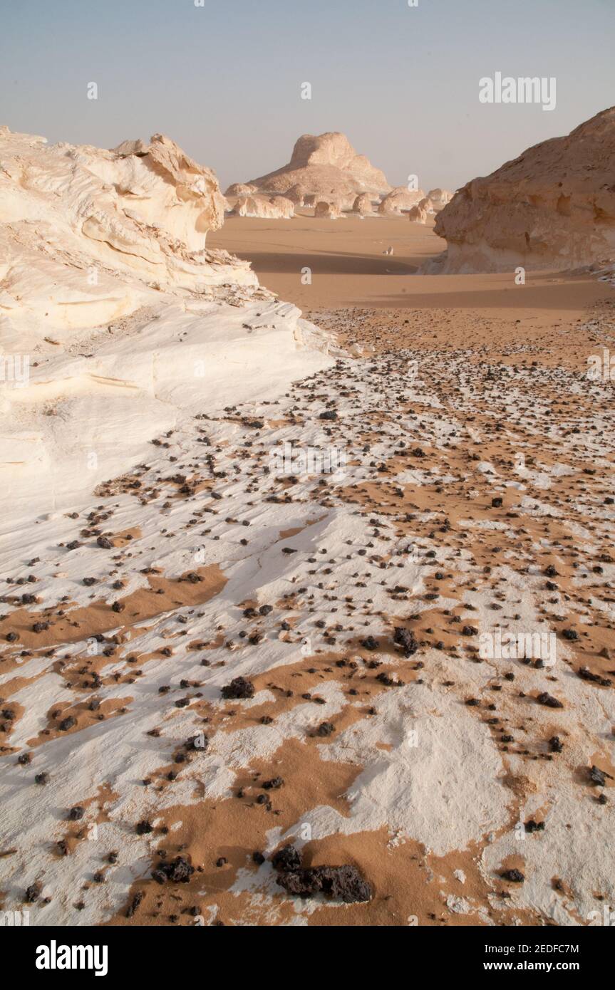 White chalk rock formations and inselbergs mixed with sand in White Desert National Park, in the Farfara Depression, Sahara region, of Egypt. Stock Photo