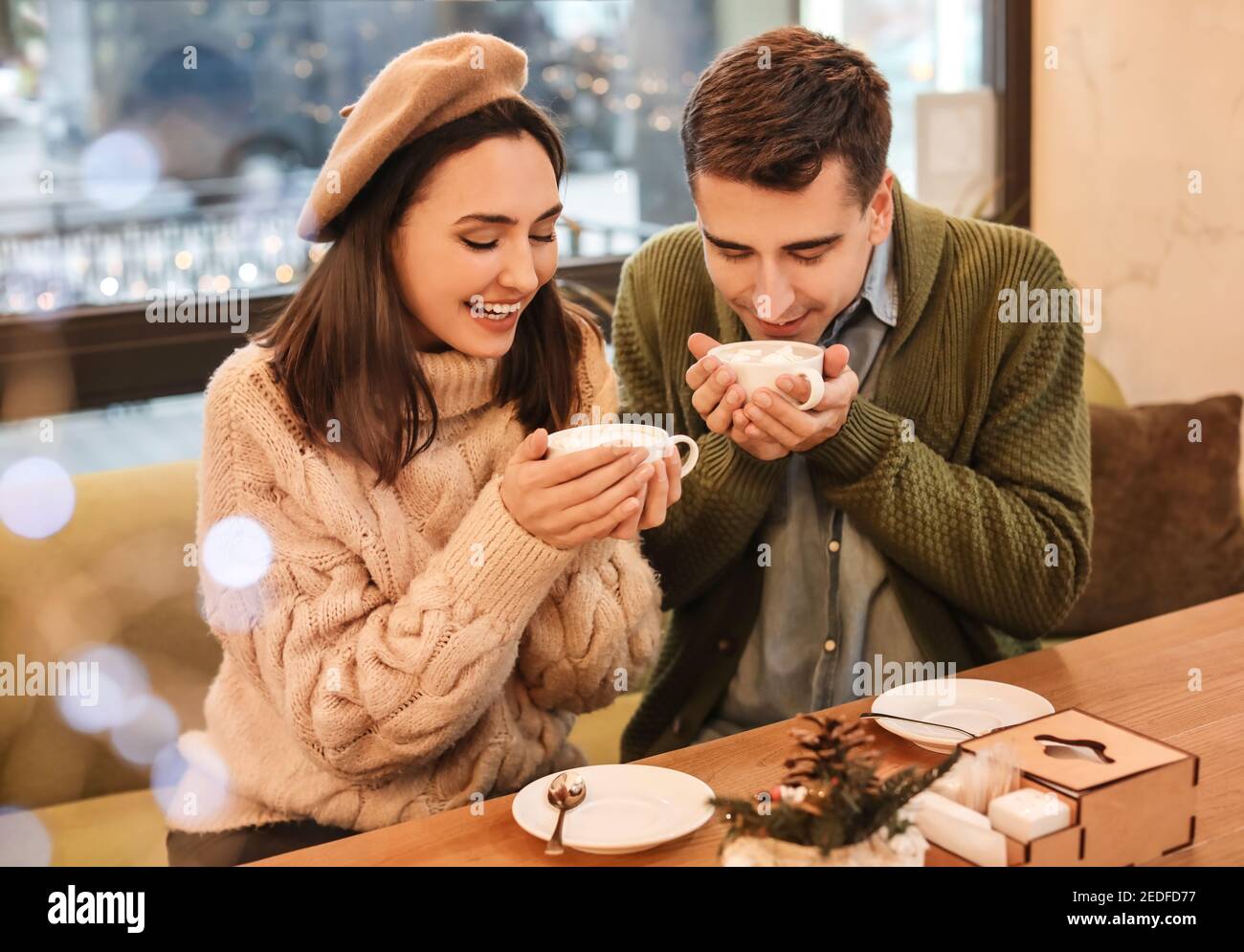 Happy young couple drinking hot chocolate in cafe on Christmas eve Stock  Photo - Alamy