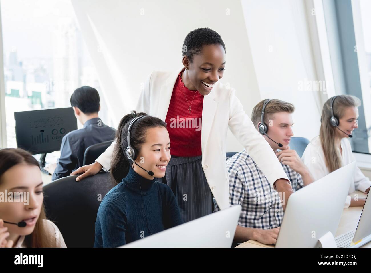 African American female supervisor training work to multiethnic team in call center headquarter office Stock Photo