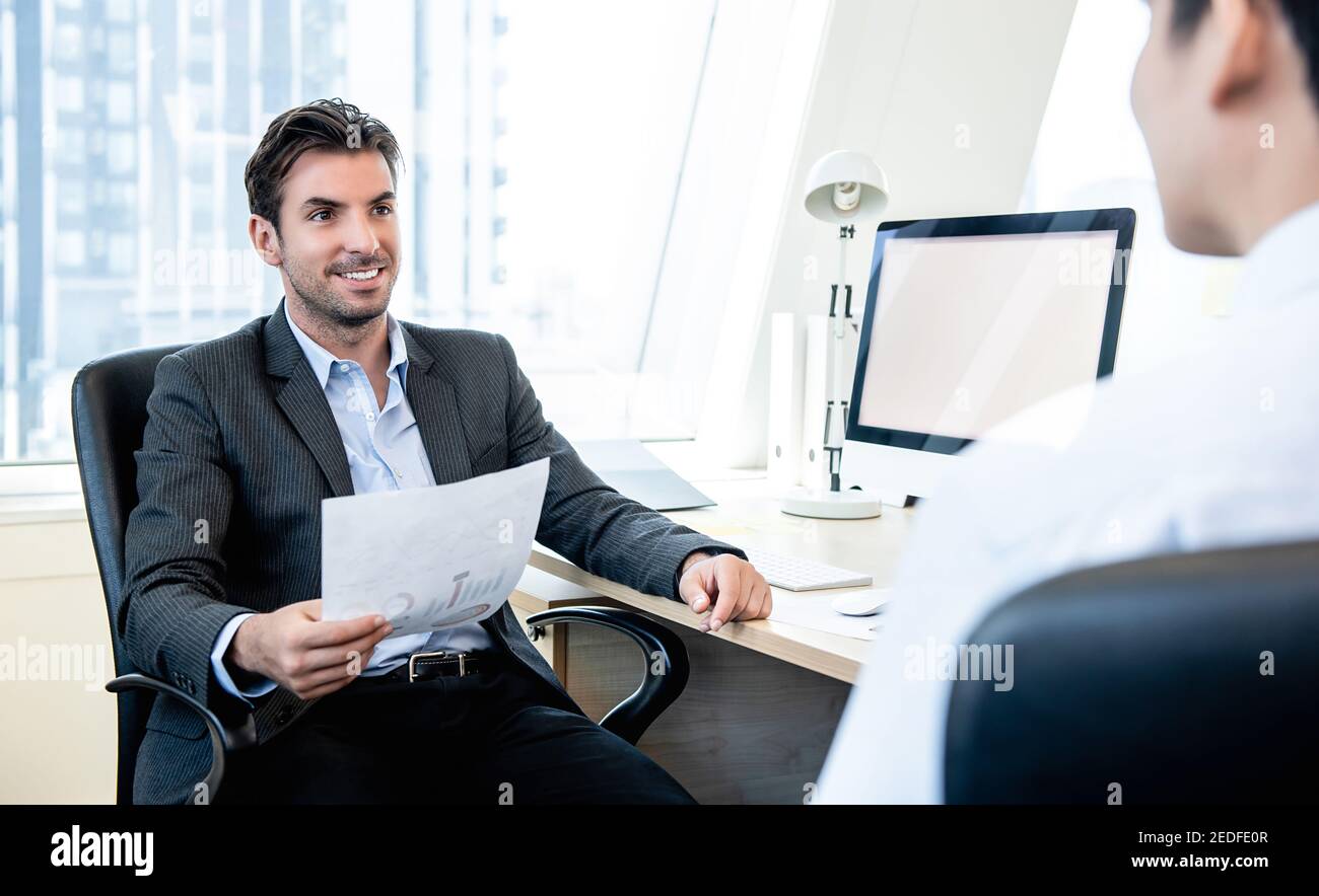 Handsome Hispanic businessman as a boss interviewing his team in the office Stock Photo