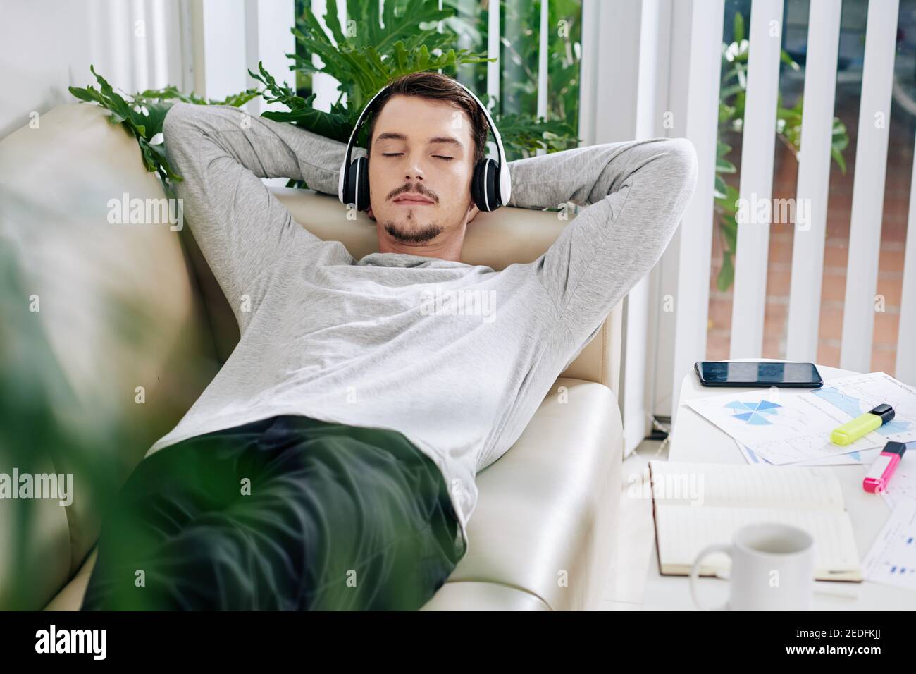 Man relaxing on sofa Stock Photo Alamy