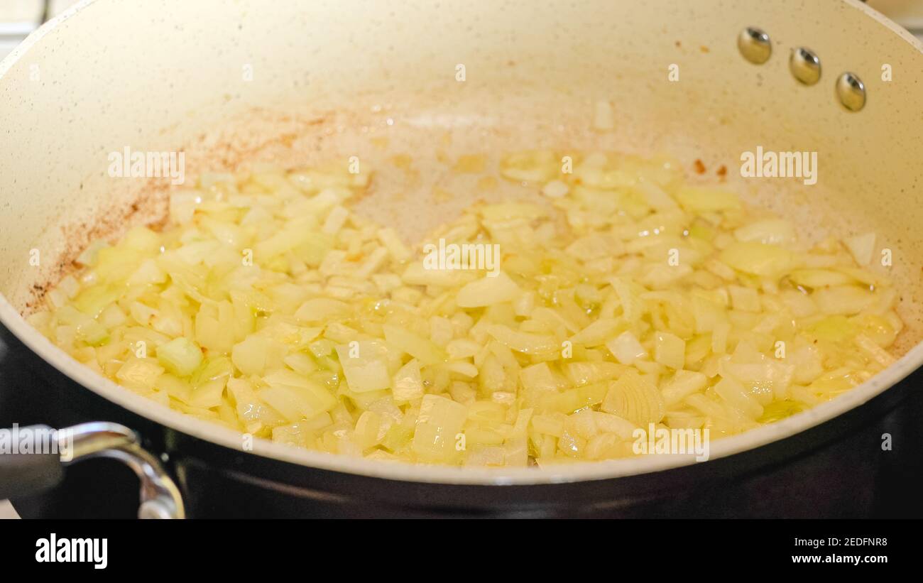 Fried chopped onion on frying pan, close up cooking process, recipe