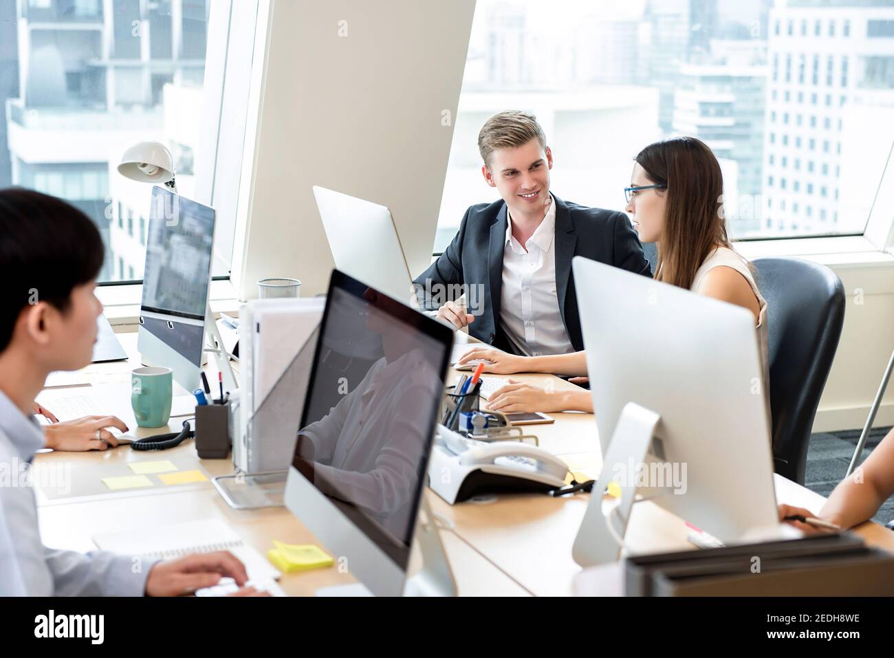 Group of business people coworkers working in office space on high rise building in the city Stock Photo