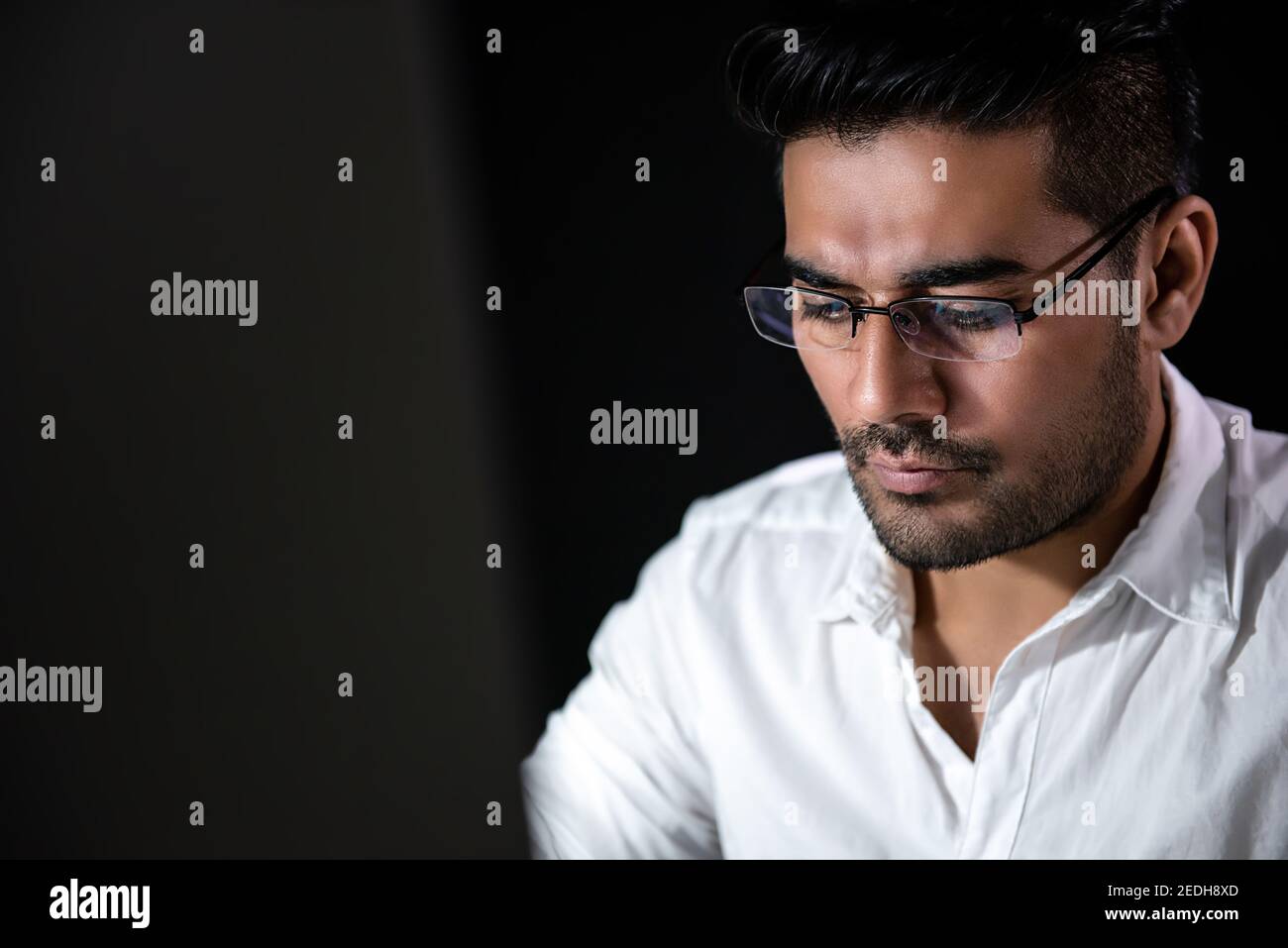 Handsome Asian businessman concentrating on working at night with serious face Stock Photo