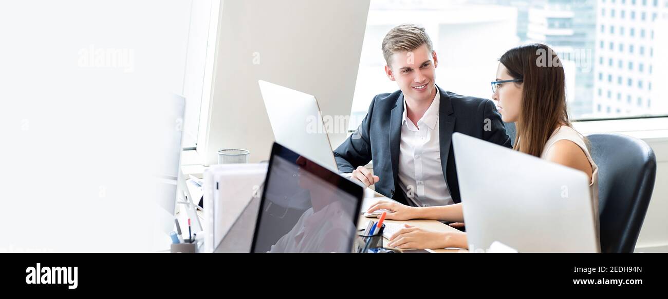 Happy business people coworkers working in office space on high rise building in the city, panoramic banner with copy space Stock Photo