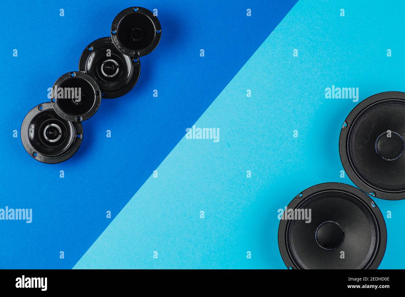 Car audio, car speakers lie in a row on a blue background. Copy space Stock Photo