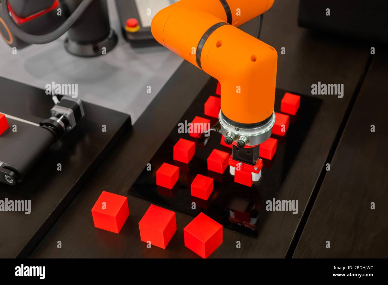 Pick and place robotic arm manipulator moving red toy blocks at robot exhibition Stock Photo