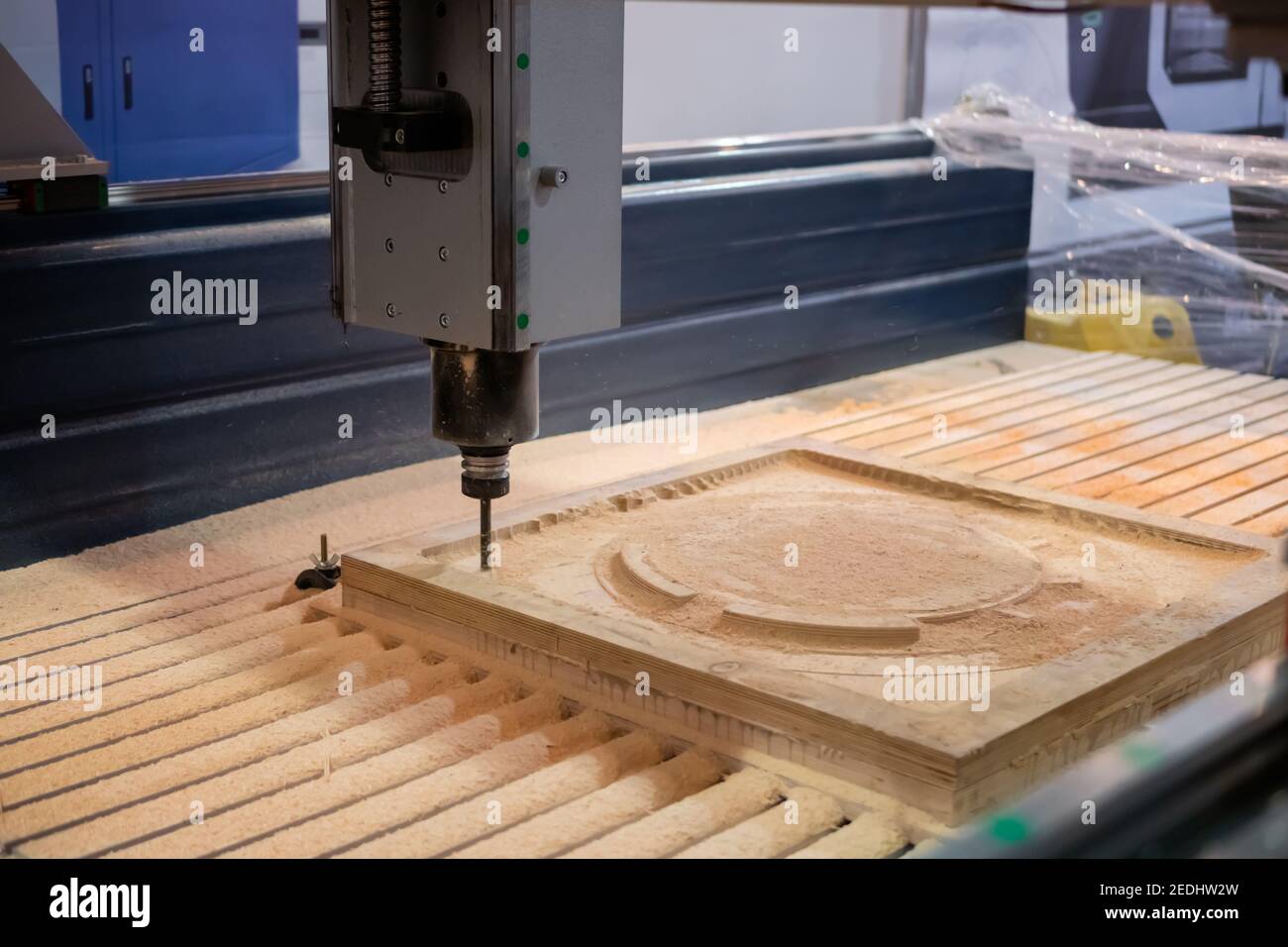 Milling machine cutting wooden workpiece from wood pulp at technology