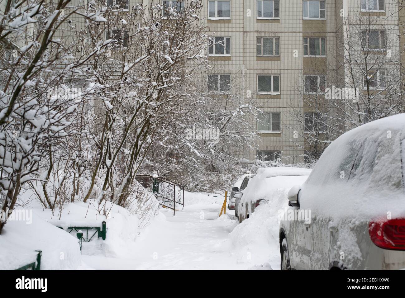 Cars in the yard of a house during heavy snowfall in Russia Stock Photo ...