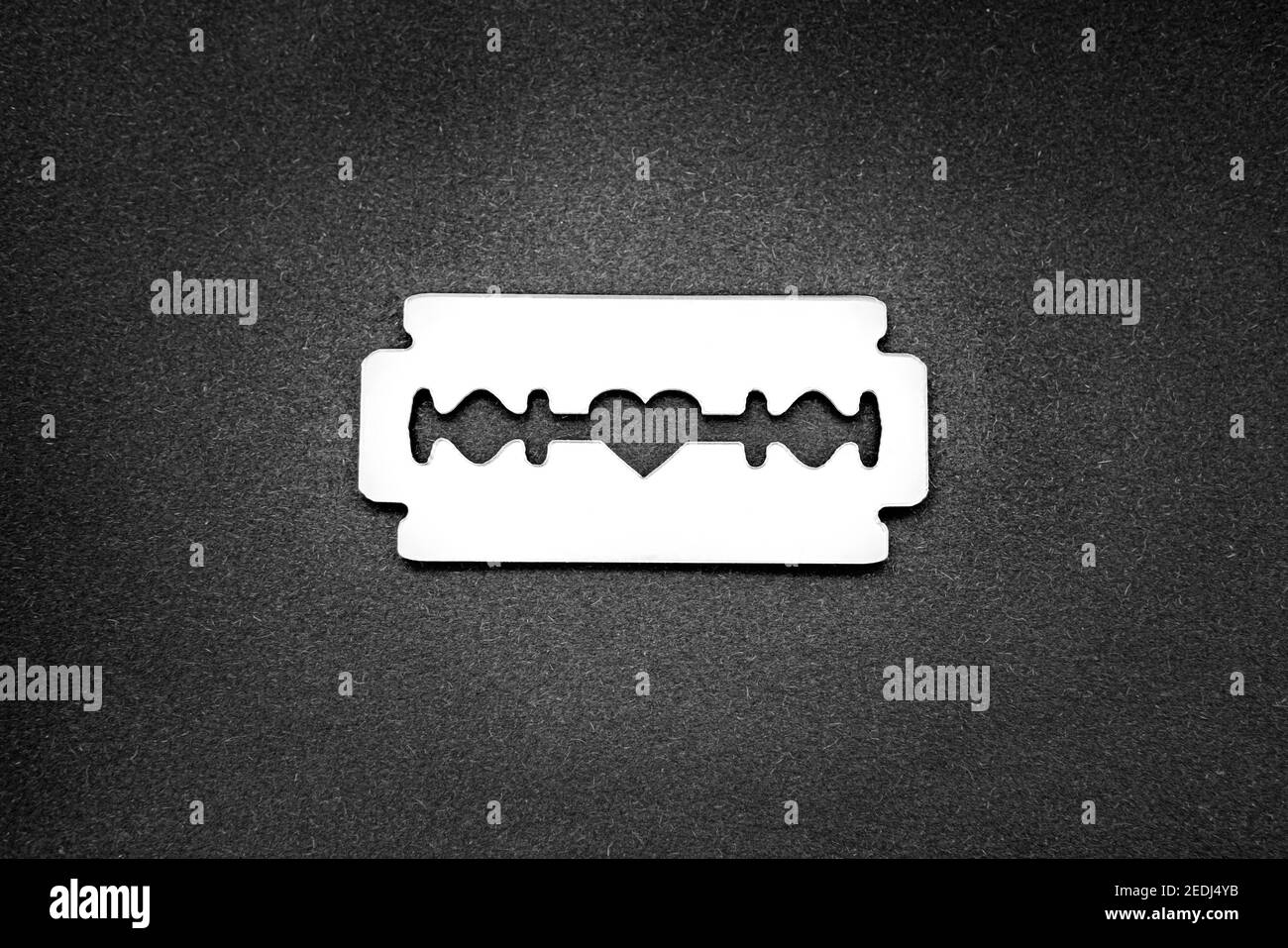 Mirror surface razor blade with a heartshaped opening in the middle on