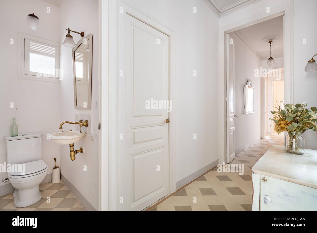 Hallway decorated in vintage style with view to small toilet and other ...