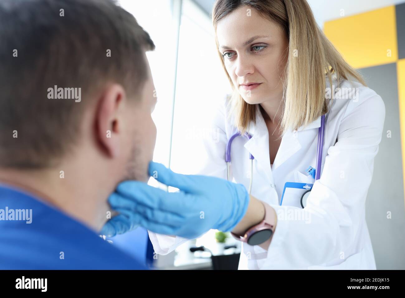 Female doctor palpating patients submandibular lymph nodes Stock Photo