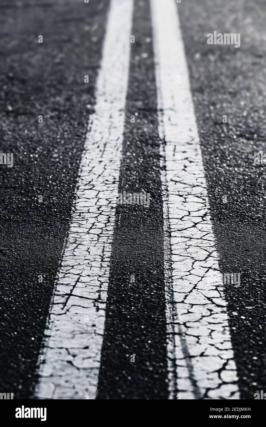 Two white lines on black asphalt perspective view into the distance