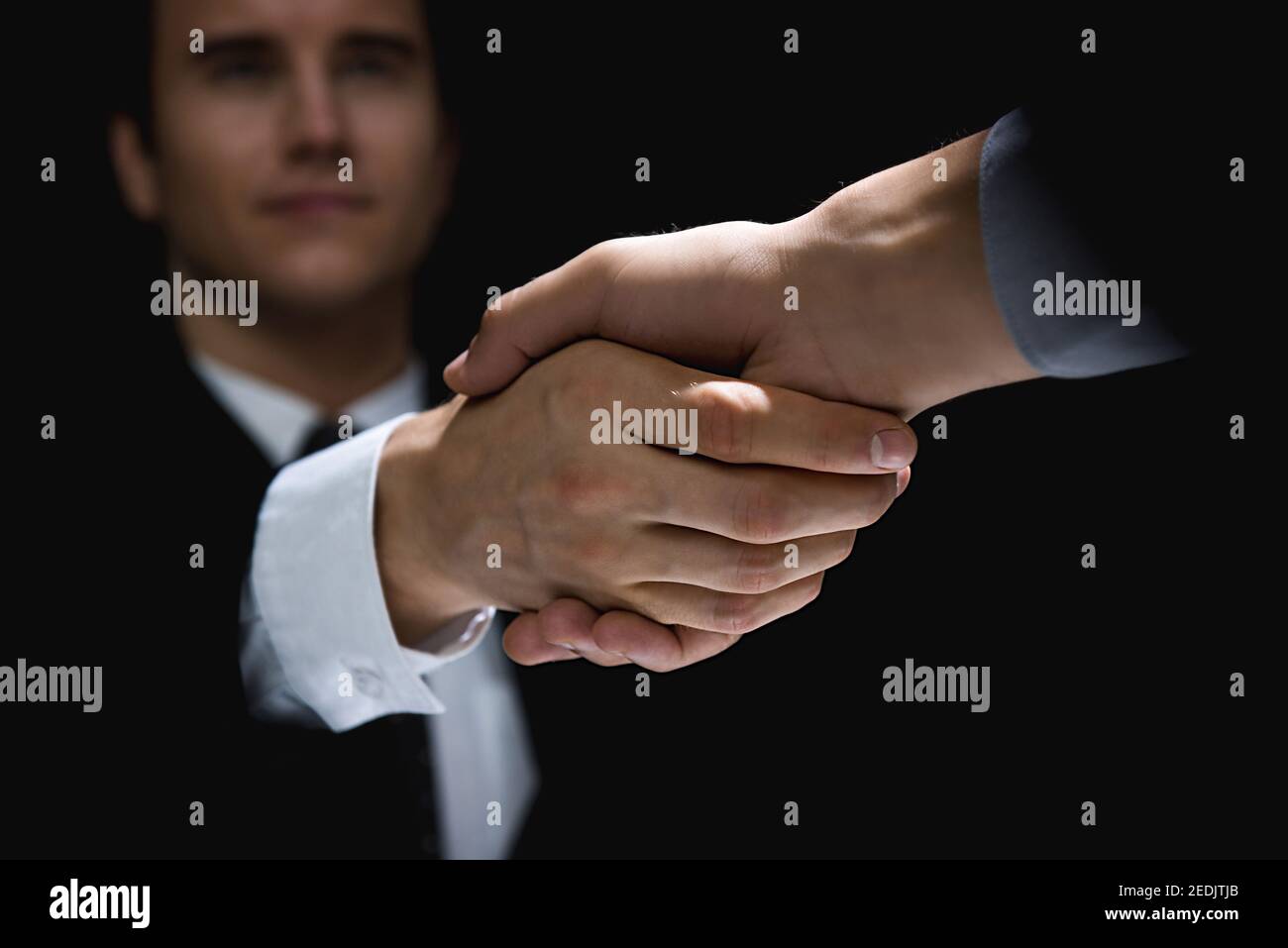 Business partners making handshake in dark shadow Stock Photo