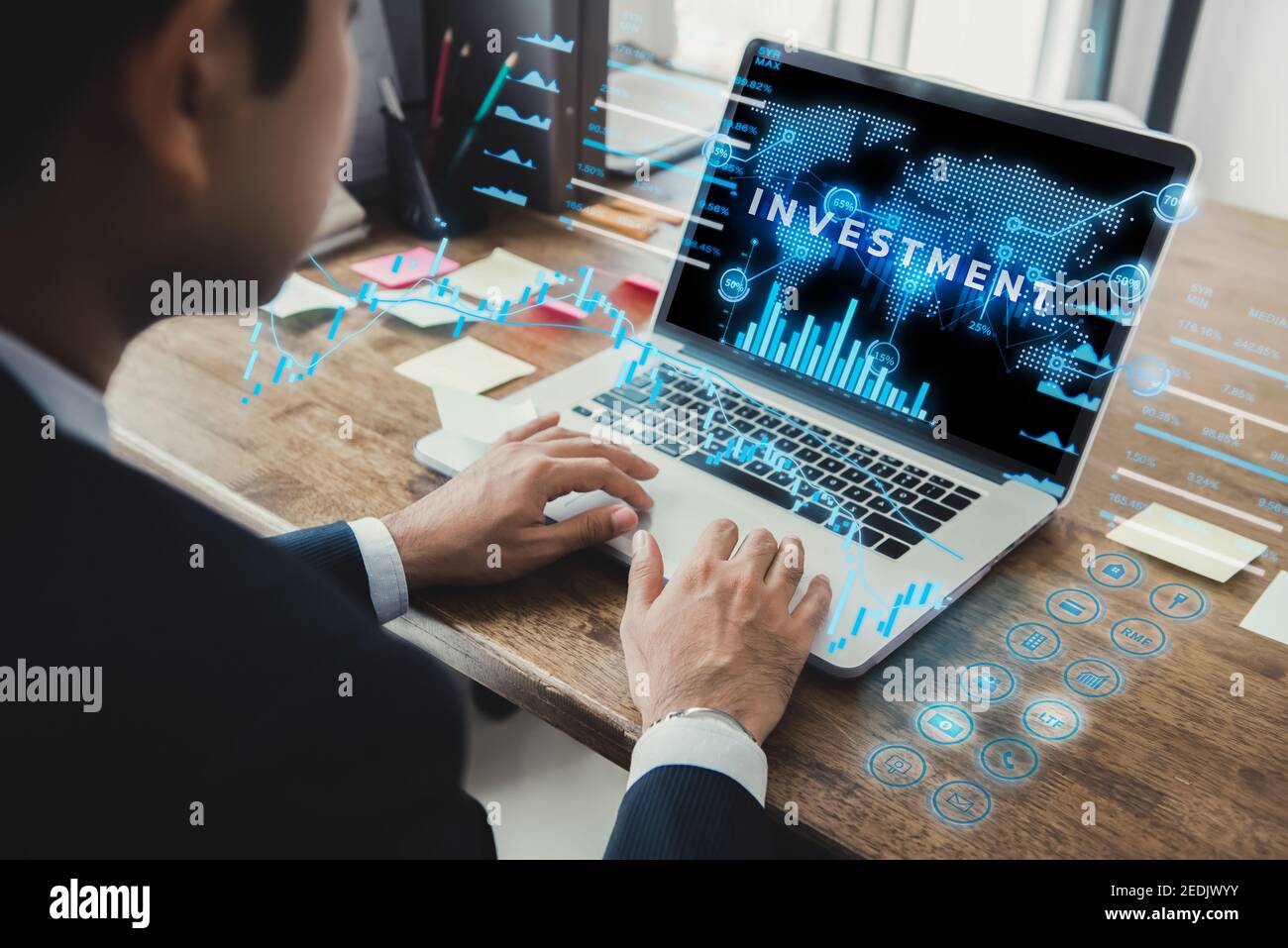 Businessman using laptop computer with futuristic online financial and investment technology digital data display, fintech concept Stock Photo