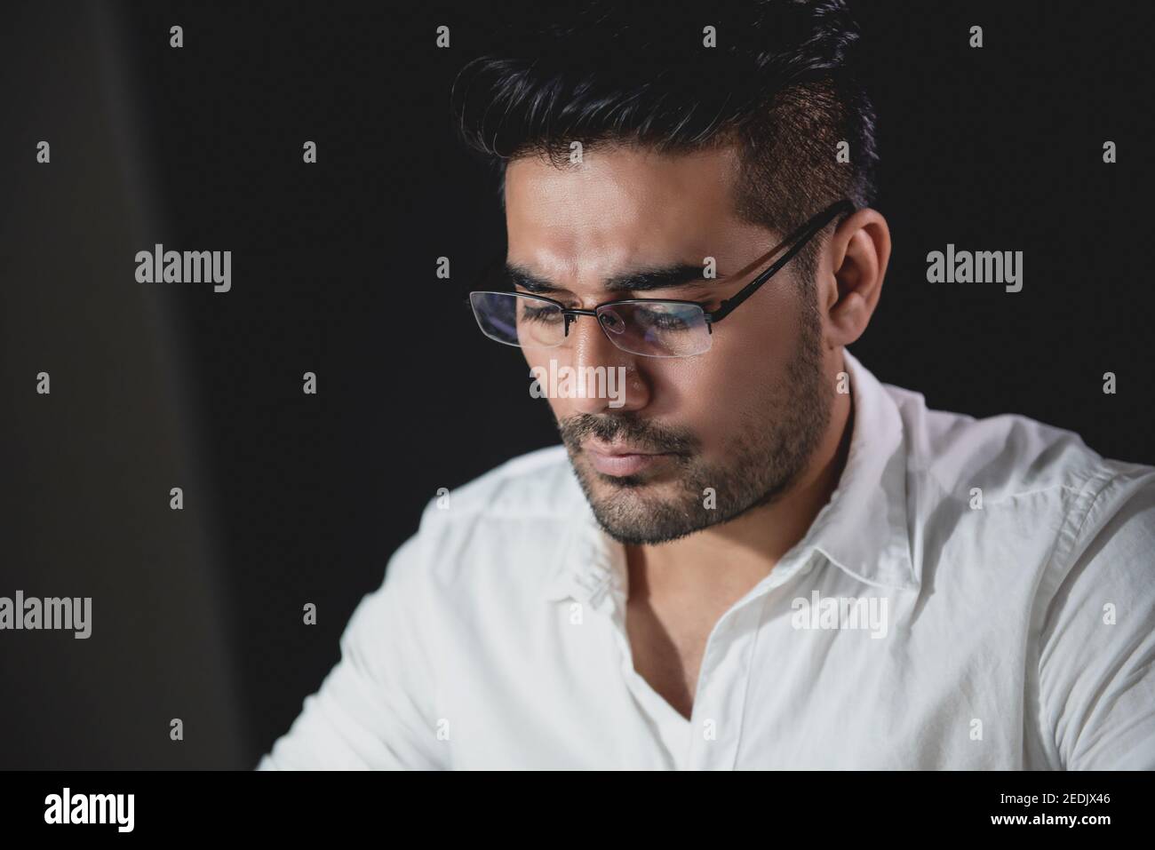 Handsome Asian businessman concentrating on working at night with serious face Stock Photo