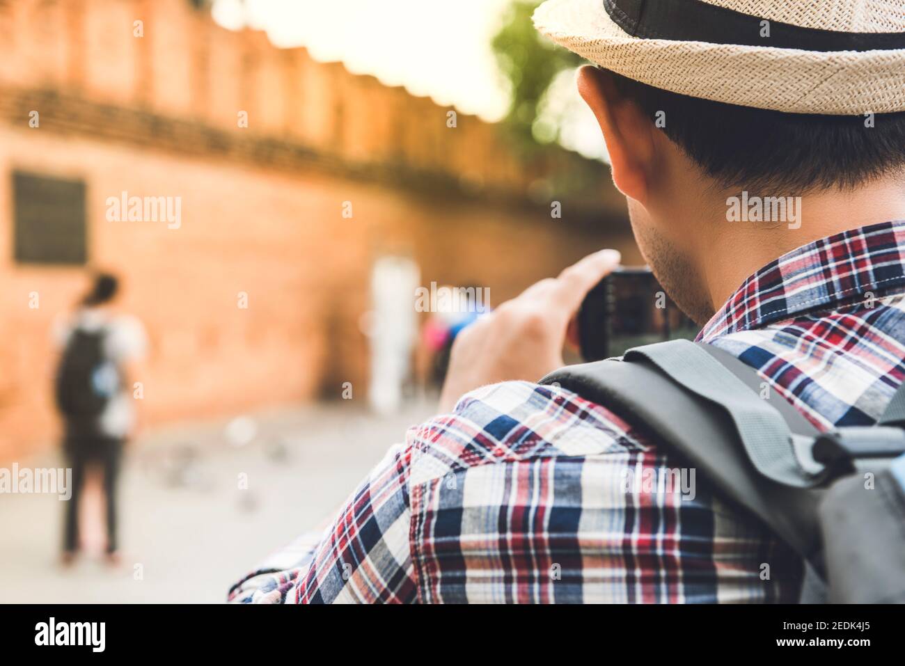 Asian male tourist backpacker taking picture at Tha Phae Gate, one of the ancient famous landmark of the city in Chiang Mai Thailand Stock Photo