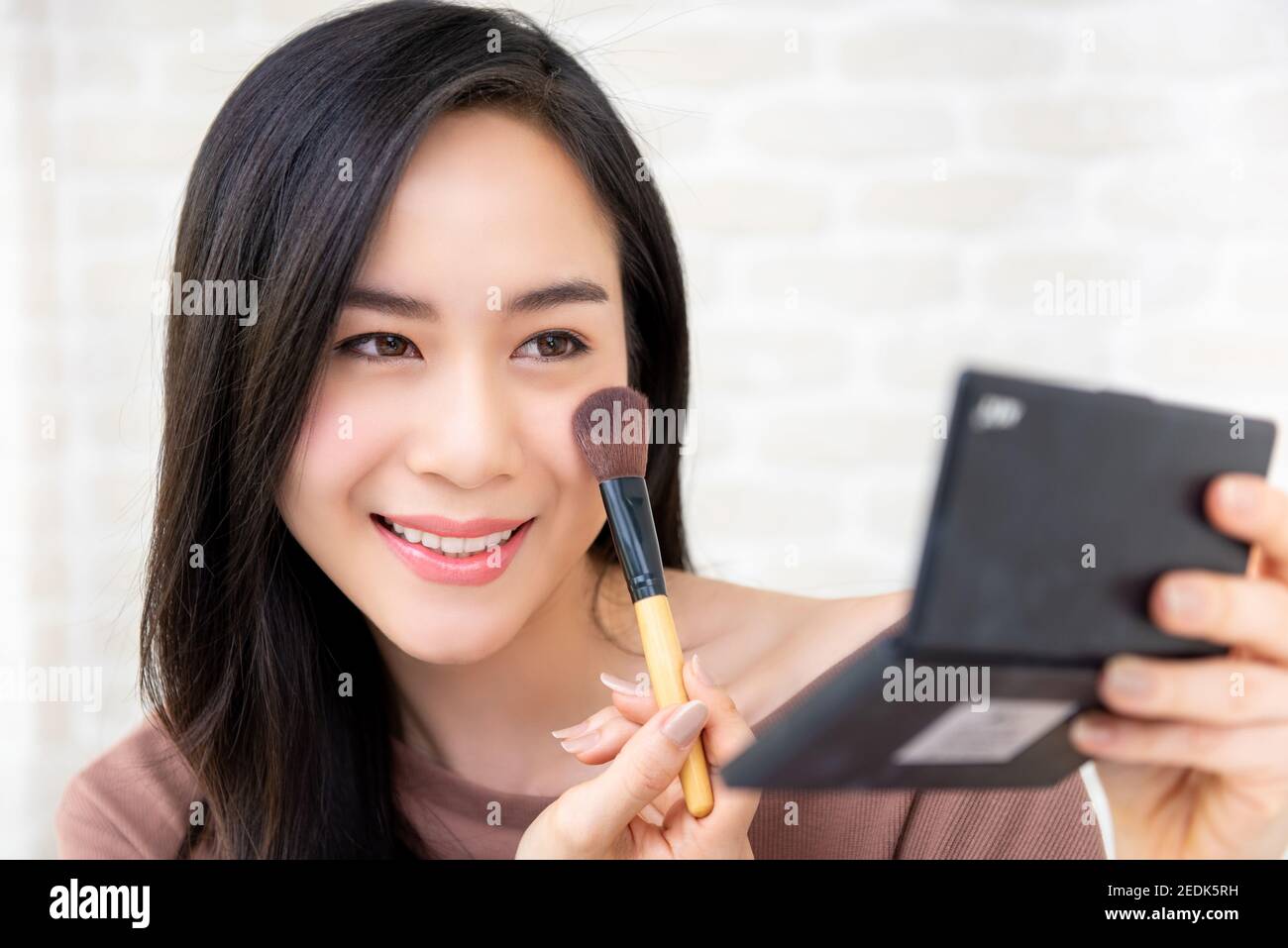 Young beautiful Asian woman professional beauty vlogger or blogger doing cosmetic makeup tutorial Stock Photo