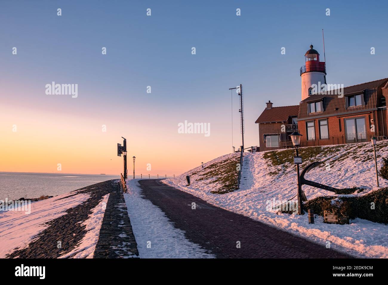 snow covered beach during wnter by Urk lighthouse in the Netherlands
