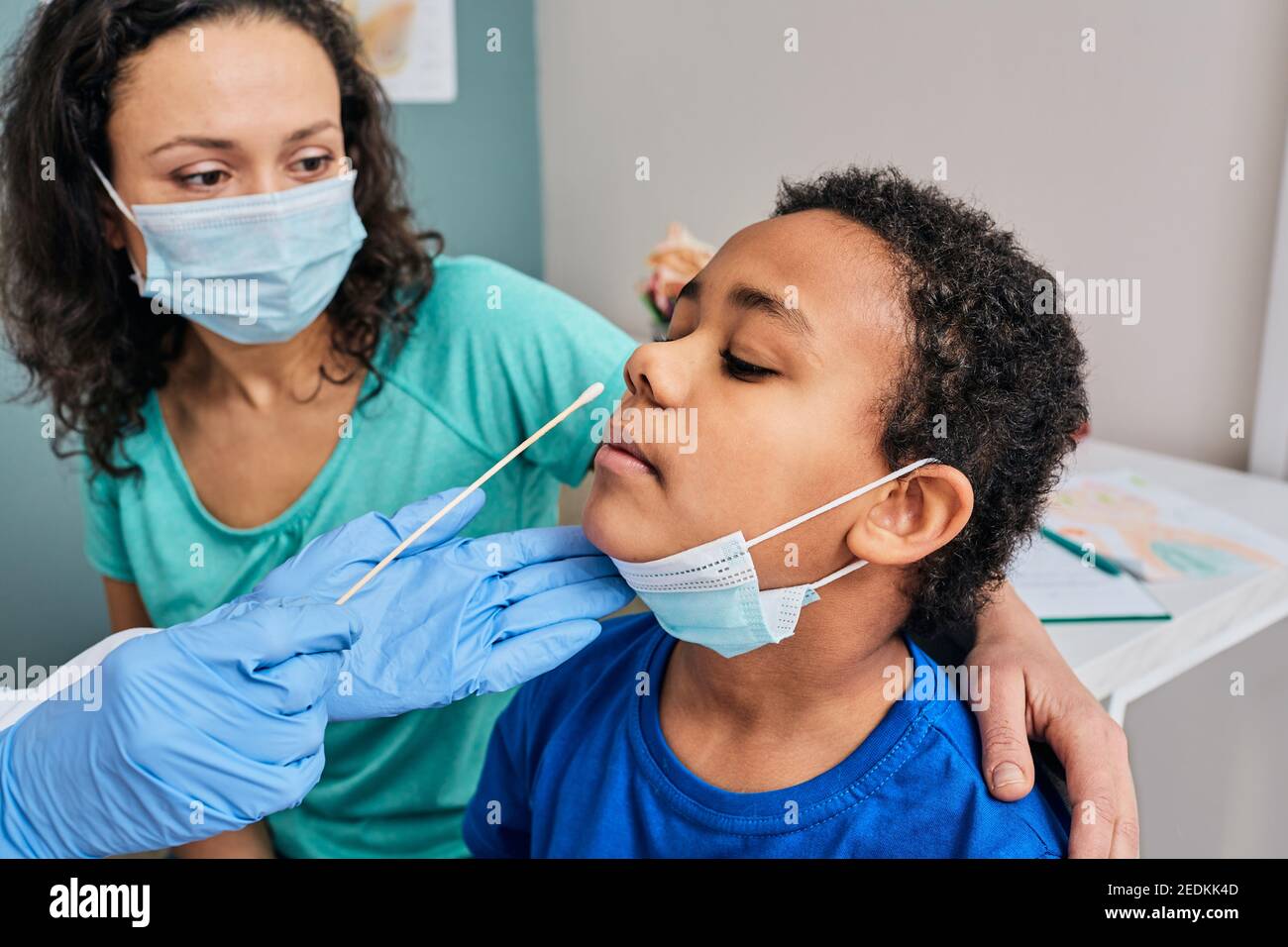 African American little boy with his mother during PCR test of coronavirus in a medical lab. Laboratory assistant taking a nasal swab for coronavirus Stock Photo
