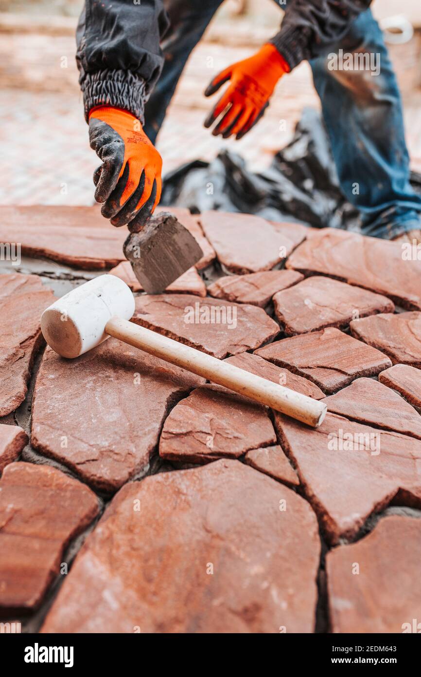 Laying tiles on the floor outside the house - professional tiling during work - decor with stone Stock Photo