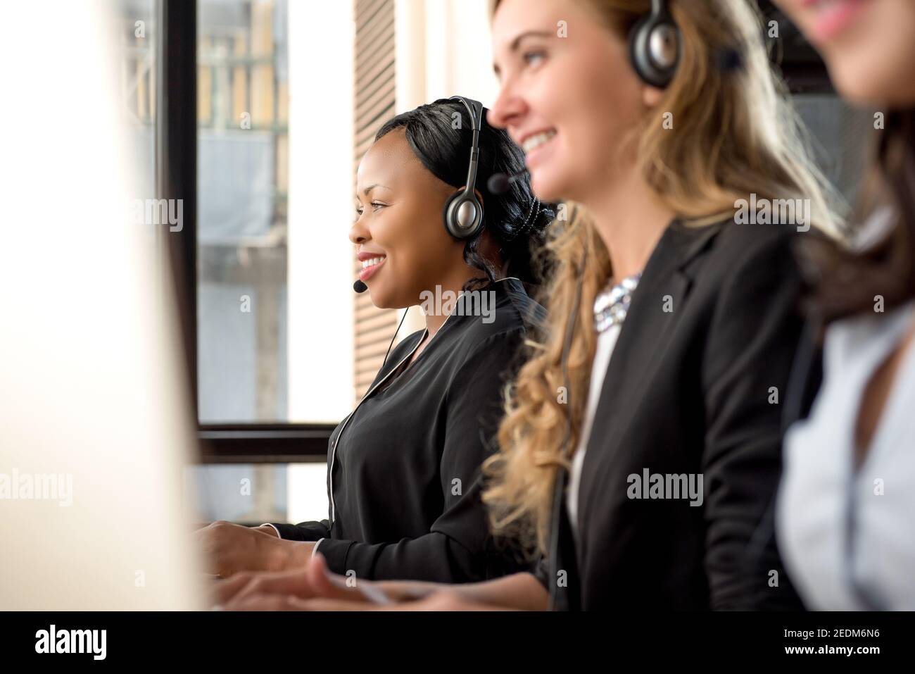 Beautiful international diverse woman telemarketing customer service team working in call center Stock Photo