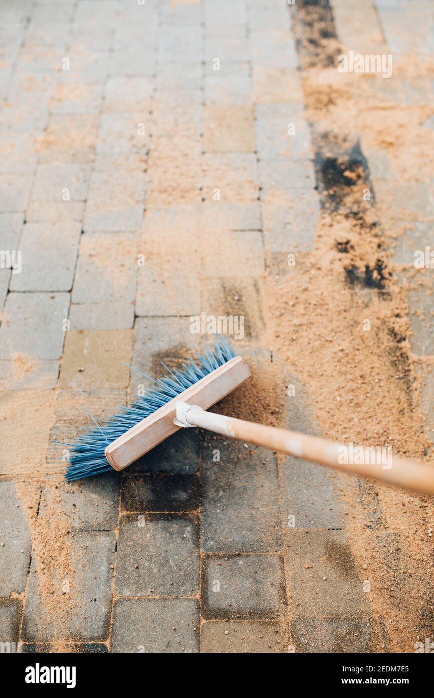 Seeded fine sand on paving slabs grouting with a brush Stock Photo