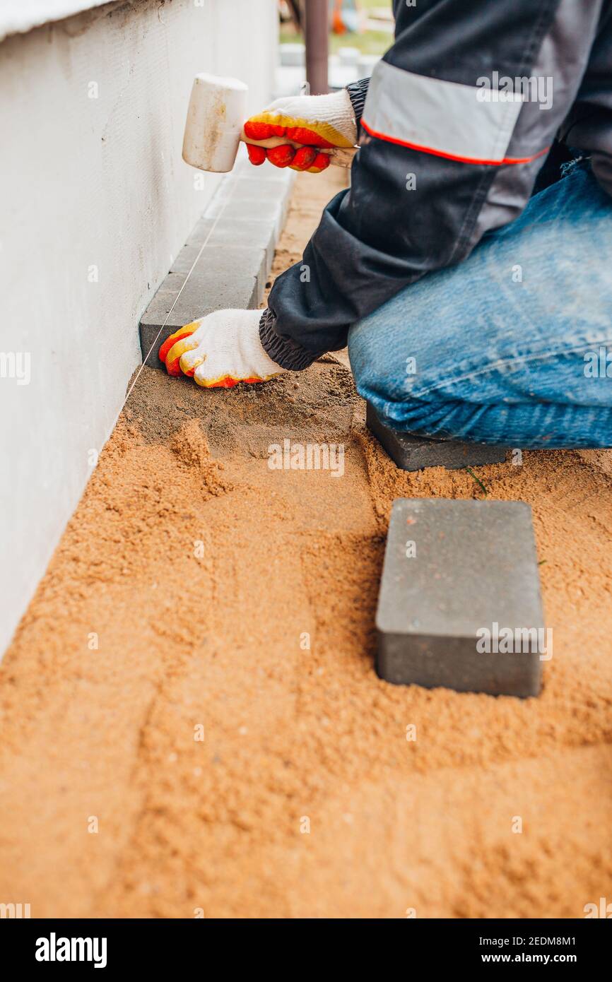 Laying stone tiles on the foundation area around the perimeter of the
