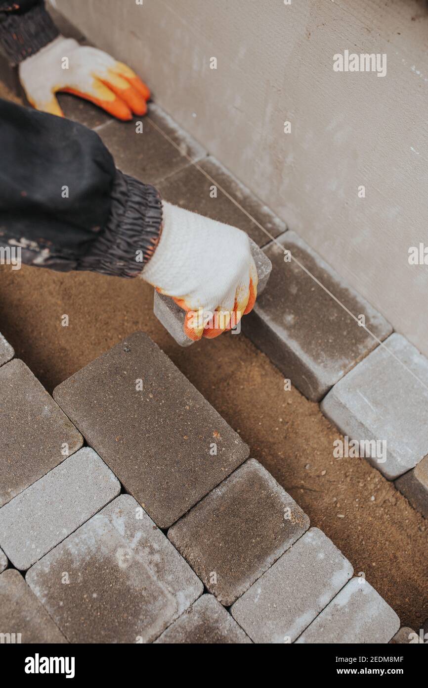 Laying stone tiles on the foundation area around the perimeter of the