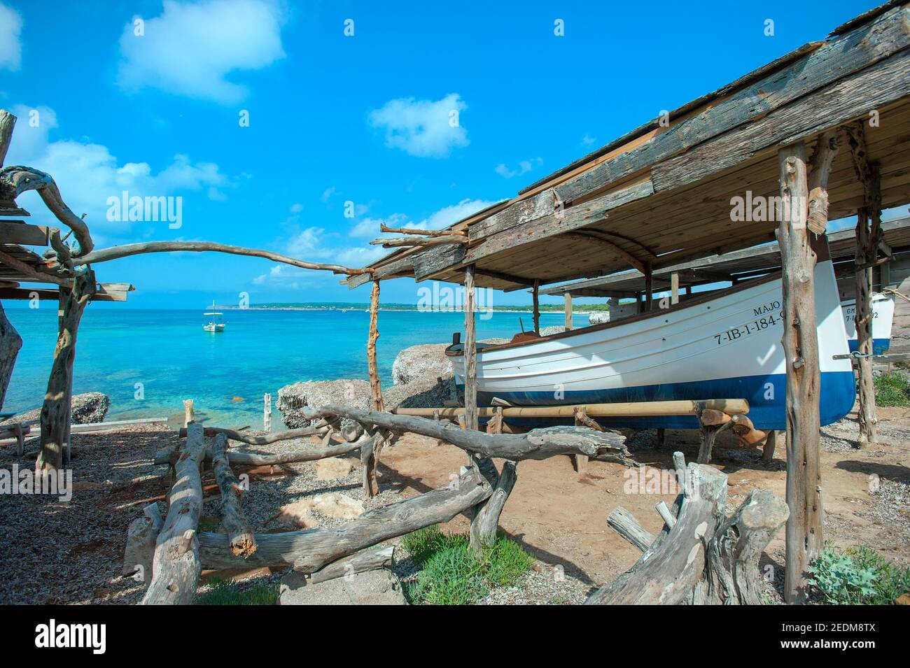 Fishing boat under wooden shelter, Playa Mitjorn, Formentera, Balearics, Spain Stock Photo