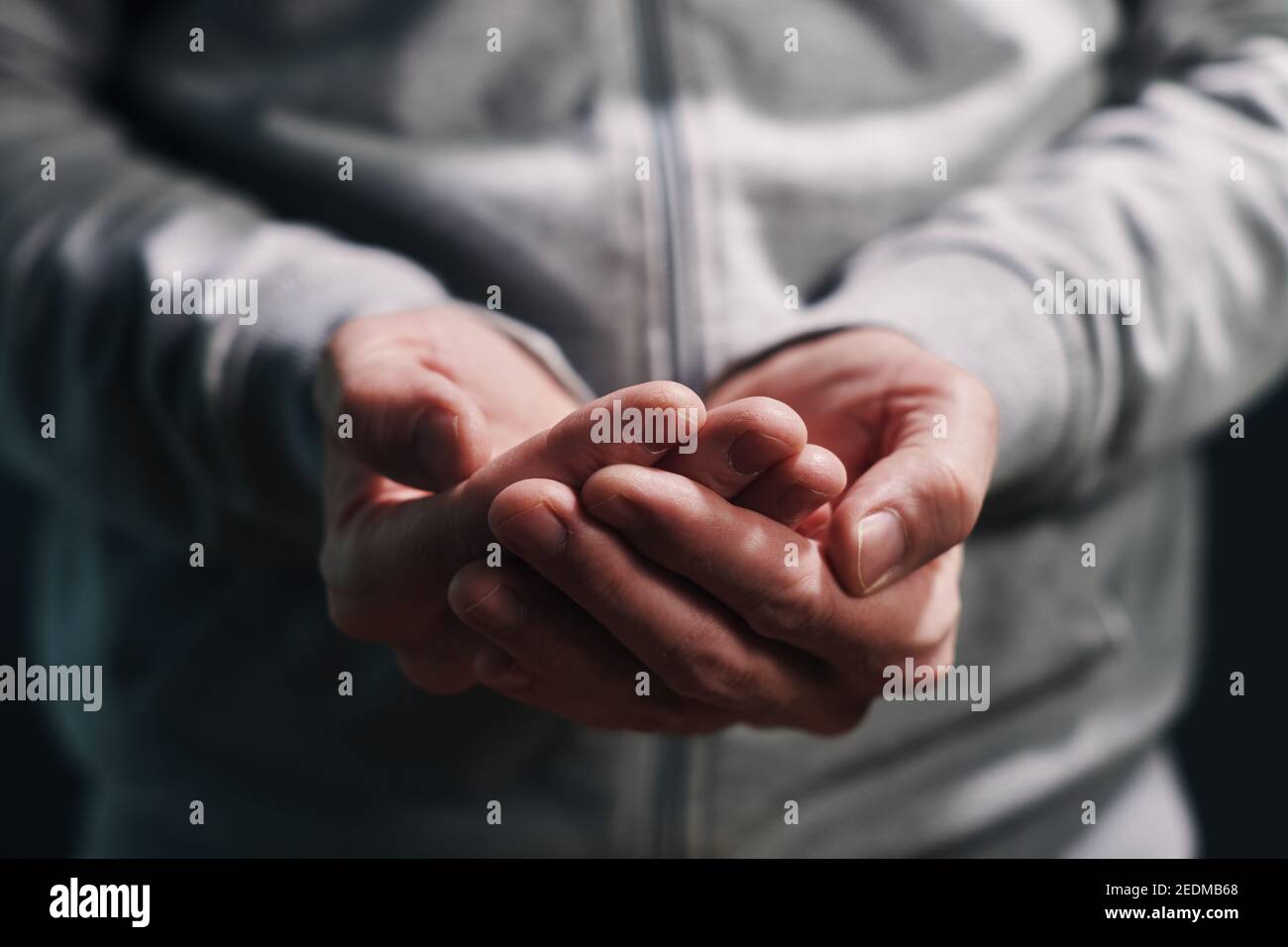 Empty cupped male hands pleading, close up with selective focus Stock Photo