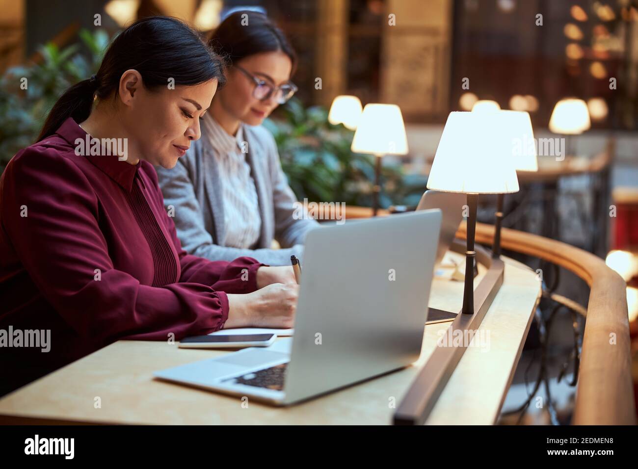 Attentive designer making notes during online lecture Stock Photo