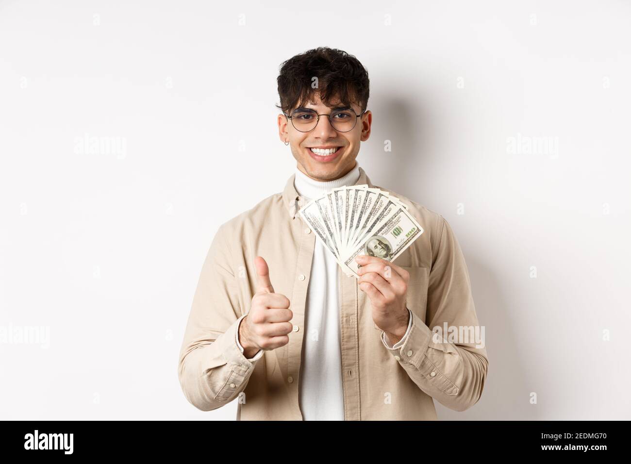 Young guy in glasses showing dollar bills and thumbs up, making money ...