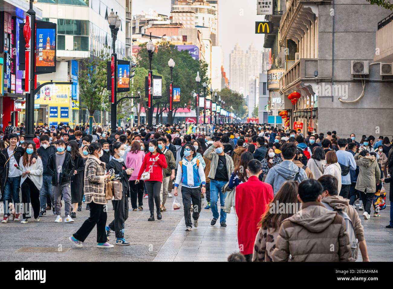 Wuhan China , 14 February 2021 : Crowd of people wearing surgical face mask on the 2021 Chinese new year week holidays in Jianghan pedestrian road in Stock Photo
