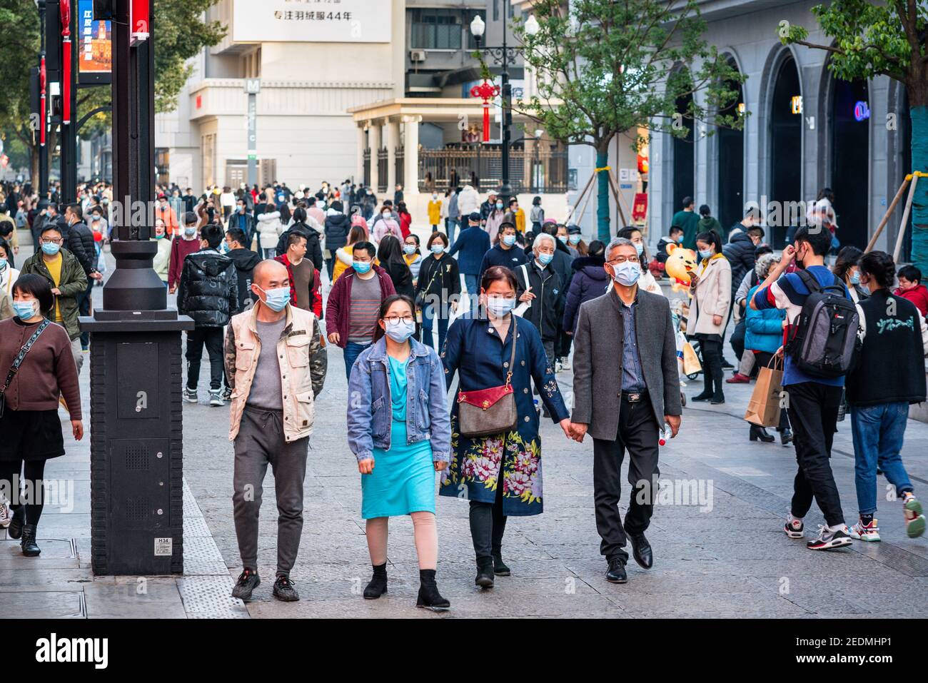Wuhan China , 14 February 2021 : People wearing surgical face mask on the 2021 Chinese new year week holidays in Jianghan pedestrian road in Wuhan Hub Stock Photo