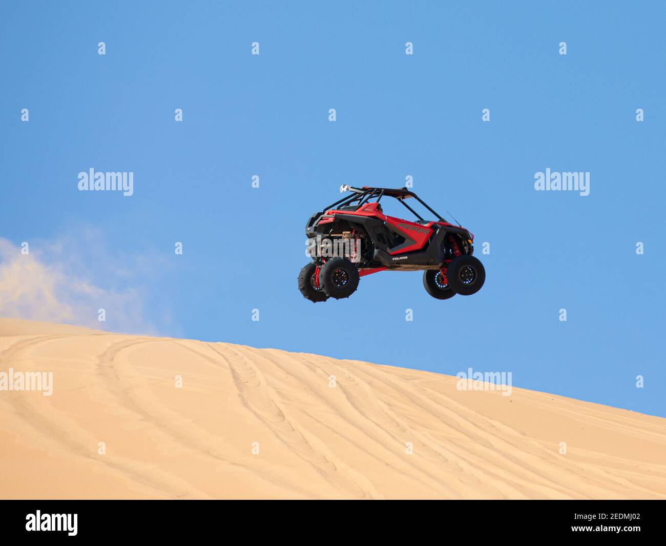 Liwa desert, Abu Dhabi, UAE - Feb 12, 2021: Dune buggy doing jumping tricks in the desert on a sunny day. Stock Photo